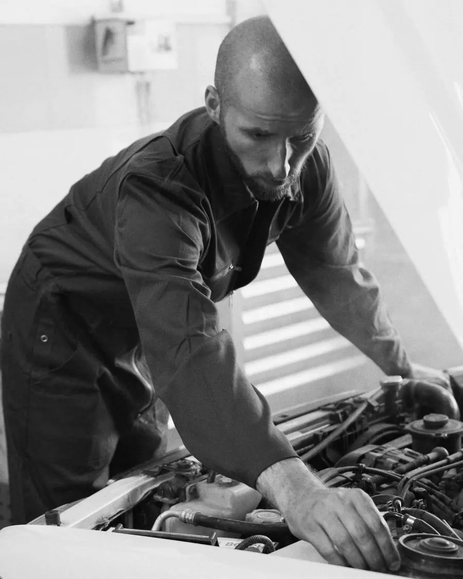 A mechanic in a workshop, working on a car.
