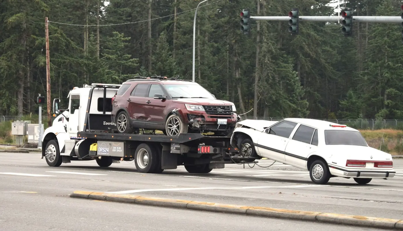 A tow truck carrying a car on its flatbed.